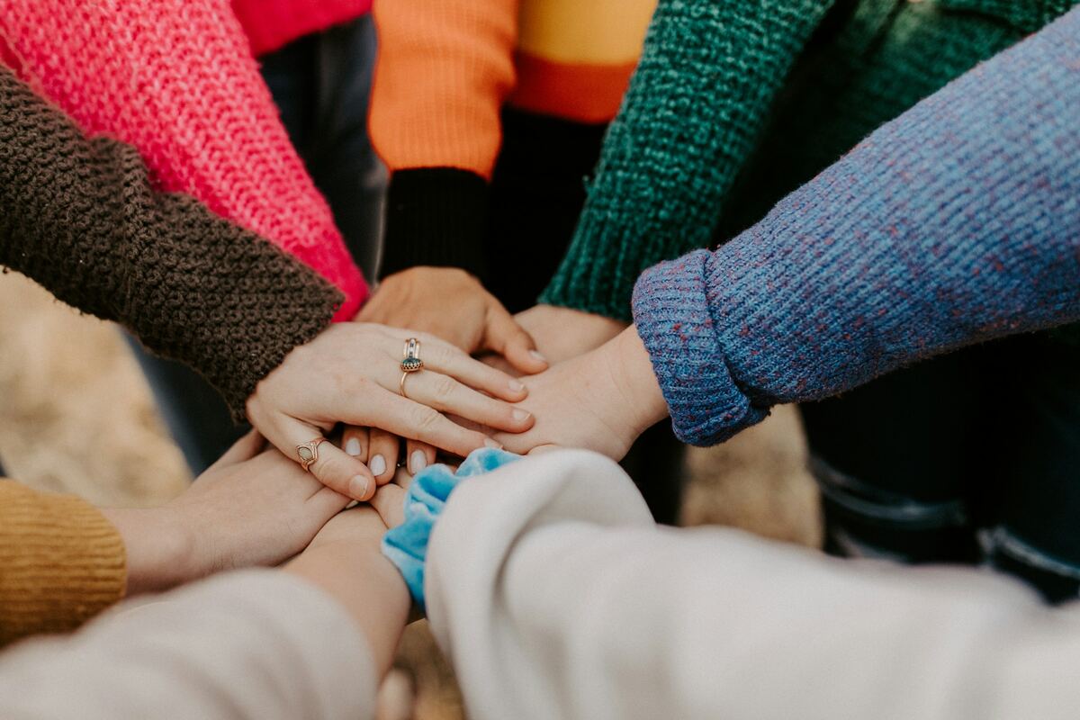 A group of people joining hands together in a circle