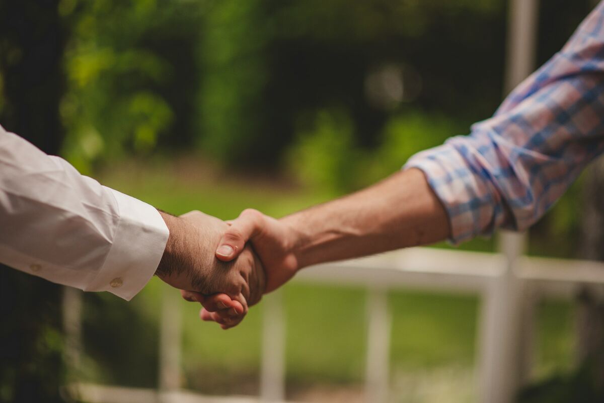 Two people shaking hands outdoors